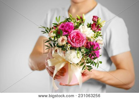Man In White T Shirt Holding In Hand Rich Gift Bouquet. Composition Of Flowers In A Pink Hatbox. Tie