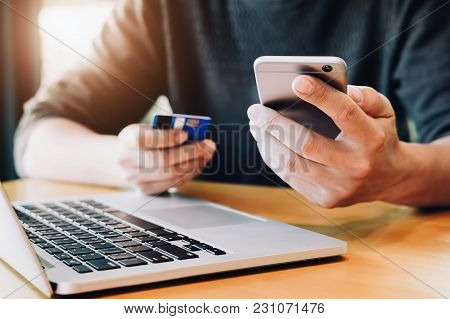 Online Payment,young Man's Hands Holding Smartphone And Using Credit Card And Computer Laptop For On