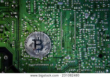 Silver Bitcoins On The Chip. The Green Background. Crypt Of Safety. Virtual Money. Mining