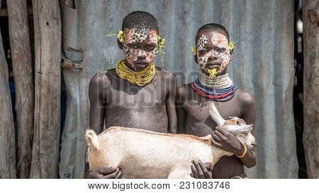 Omo Valley, Ethiopia, September 2017: Portrait Of Unidentified Karo Tribe Children Holding A Goat, C
