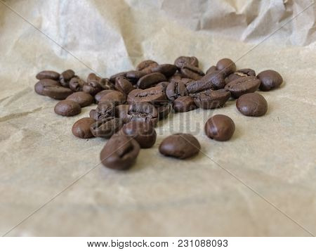 Coffee Beans On Paper Background. Closeup Photo
