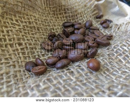 Coffee Beans On Sack Background. Closeup Photo