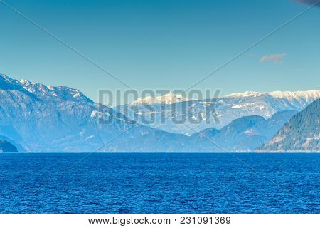 Fantastic view over ocean, snow mountain and rocks at Sechelt inlet in Vancouver, Canada.