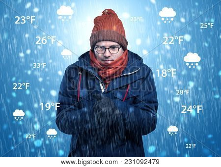 Young man freezing in warm clothing with weather condition and forecast concept