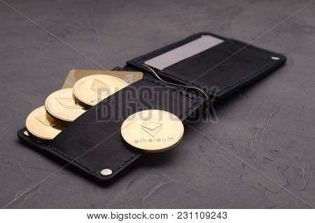 Crypto-currency: A Leather Purse With Plastic Cards And Ethereum Coins On A Gray Background