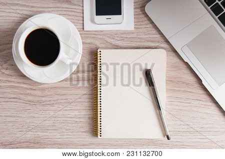 Notepad, Laptop And Coffee Cup On Wood Table