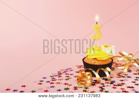 Third Birthday Cupcake With Candle And Sprinkles On Pink Background. Card Mockup, Copy Space. Birthd