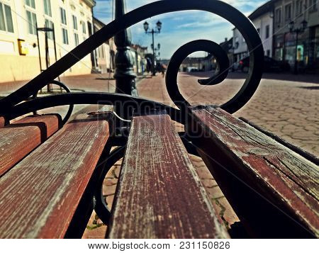 Na Wooden Bench In The Center Of A Cute Little Town In Serbia. Market And Buildings. Irig Serbia