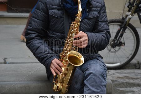 A Street Musician Is Playing For Money