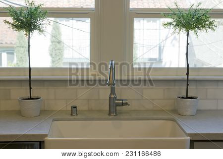 White Apron Front Kitchen Sink With Chrome Faucet And Fixtures.