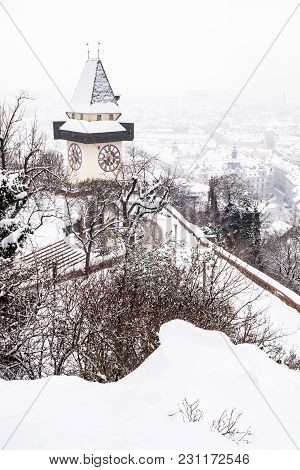 Snow Covered Uhrturm Clocktower Landmark On Hill Schlossberg With Aerial View To City Graz In Winter