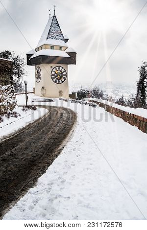 Sun Flares Over Snow Covered Uhrturm Clocktower Landmark On Hill Schlossberg With Aerial View To Cit