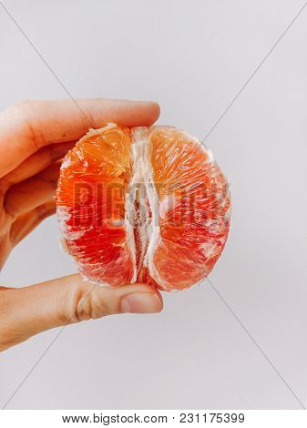 Girl Holds A Half Of Blood Orange Vertical