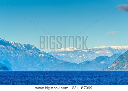 Fantastic view over ocean, snow mountain and rocks at Sechelt inlet in Vancouver, Canada.