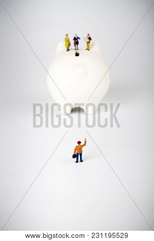 Businessman Figurines On A Piggybank. Money, Business And Expectation Concept.