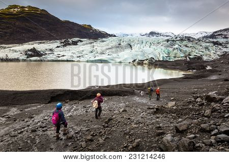 Group Of Hikers Walking To Glacier With Guide