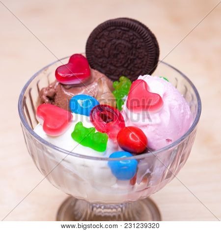 Pink ice cream croissant with biscuits and sweets