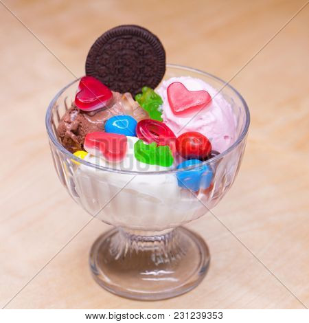 Pink ice cream croissant with biscuits and sweets