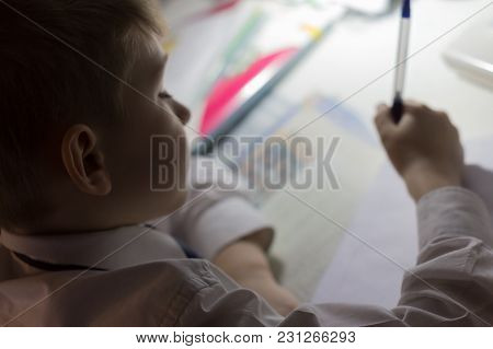 Close-up Of Boy Hand With Pencil Writing English Words By Hand On Traditional White Notepad Paper. B