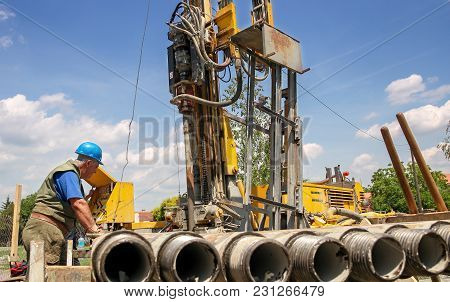 Geothermal Drilling Rig Workers.  Drilling Geothermal Well For A Residential Geothermal Heat Pump.