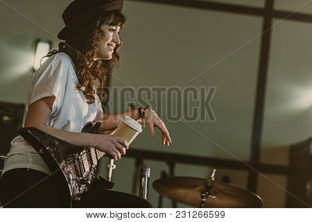 Beautiful Female Musician With Electric Guitar And Cup Of Coffee To Go