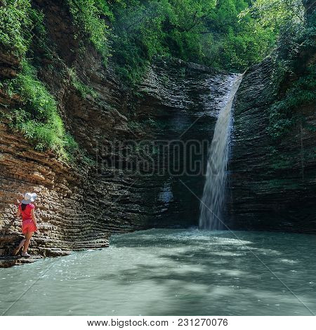 Girl In Red Looks At The Waterfall Maiden Spit On The Stream Rufabgo, Adygea, Russia