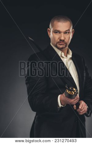 Handsome Mature Man In Suit With Katana Sword On Black