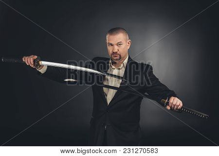 Serious Man In Costume With Dual Katana Swords On Black
