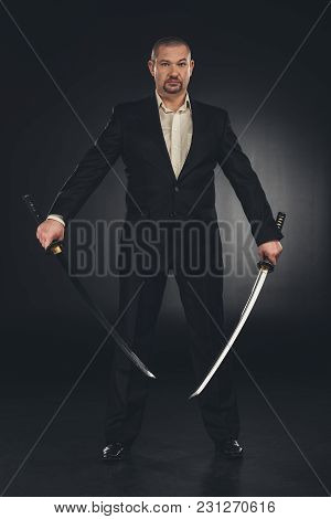 Man In Costume With Dual Katana Swords On Black