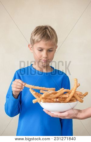 Child Eating Popular Sweat Spanish Dessert Churros.