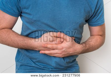 Man With Stomach Pain Is Holding His Aching Belly - Body Pain Concept