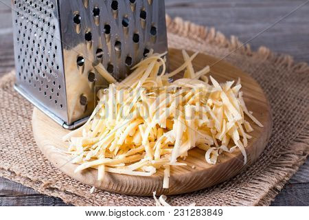 Grated Cheese On A Wooden Cutting Board