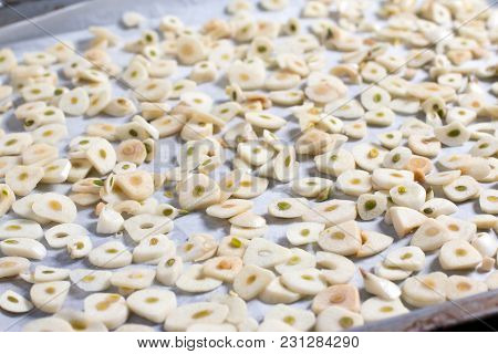 Slices Of Garlic On A Baking Sheet For The Preparation Of Dried Seasoning, Close Up