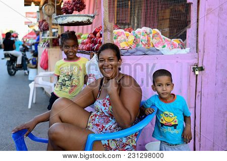 La Romana, Dominican Republic - 02 December 2017: Laughing Woman Selling Vegetables And Fruits With 