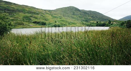 Lake And Green Hills. A Scenic View Of A Kerry Mountains And Surrounding Areas In County Kerry. Aged