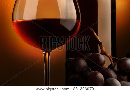 Goblet Of Red Wine With Bottle And Bunch Of Grap