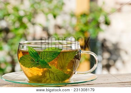 Glass Of Tea On The Wooden Desk In The Garden