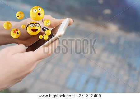 Close-up Of Woman Using Smartphone Sending Emojis. Social Concept.