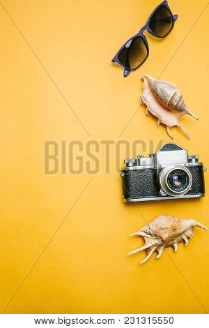 Accessories A Traveler On A Yellow Background With Sunglasses, Shell And A Camera.