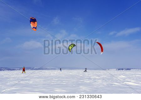 Perm, Russia - March 09, 2018: Snow Kiters Train On The Ice Of A Frozen Lake In The Background Of A 
