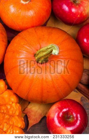 Autumn Pumpkin Thanksgiving Background With Orange Pumpkins, Apples And Fallen Leaves On Wooden Tabl