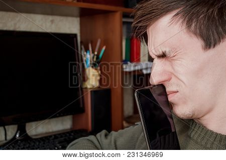 The Guy Tightly Squeezed His Eyes, Closed The Rum With A Black Smartphone, In The Workplace