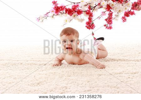 Happy Smiling The Baby Is Lying On Her Stomach On The Carpet In The Room And Smiling Under The Branc
