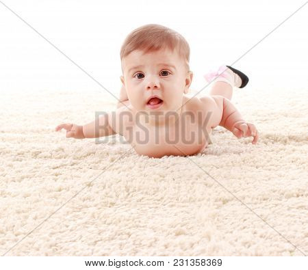 The Baby Is Lying On Her Stomach On The Carpet In The Room And Smiling On White Background