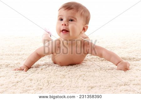 The Baby Is Lying On Her Stomach On The Carpet In The Room And Smiling On White Background