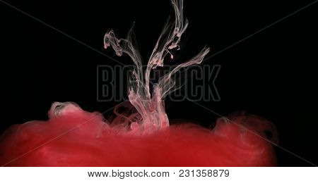Red Drops, Waves And Clouds Of Ink Creating Dynamic Shapes In Water. Abstract Effects Of Paint Color