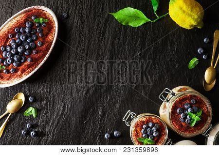 Tiramisu, Traditional Italian Dessert. With Savoyardi Cookies And Coffee. On Black Stone Background.