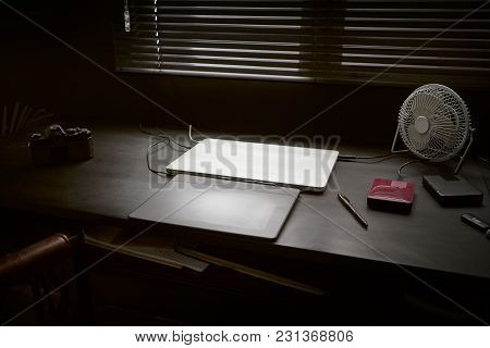 Work Space On Black Table Of A Photographer Or Designer With Laptop , Retro Camera And Fan , Stylish