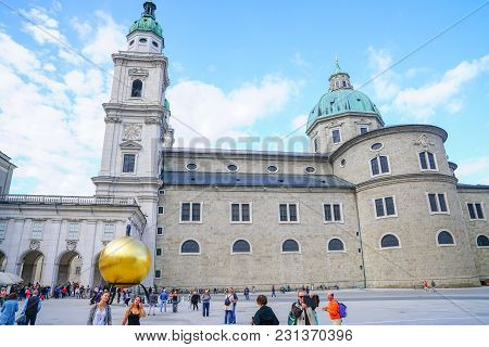 Salzburg Austria - September 6 2017; People Passing By Large Golden Sphere With Man On Top By Sculpt