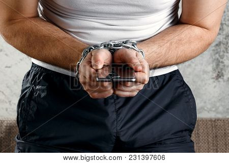 Close-up, The Man's Hand Is Tied With A Chain To The Smartphone. The Concept Is Dependent On Technol